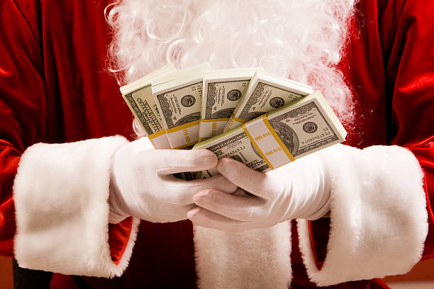 Close-up of Santas hands with stacks of dollar banknotes